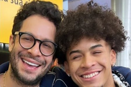 Foto colorida de Rainer Cadete com o filho. Ambos estão sorridentes - Metrópoles