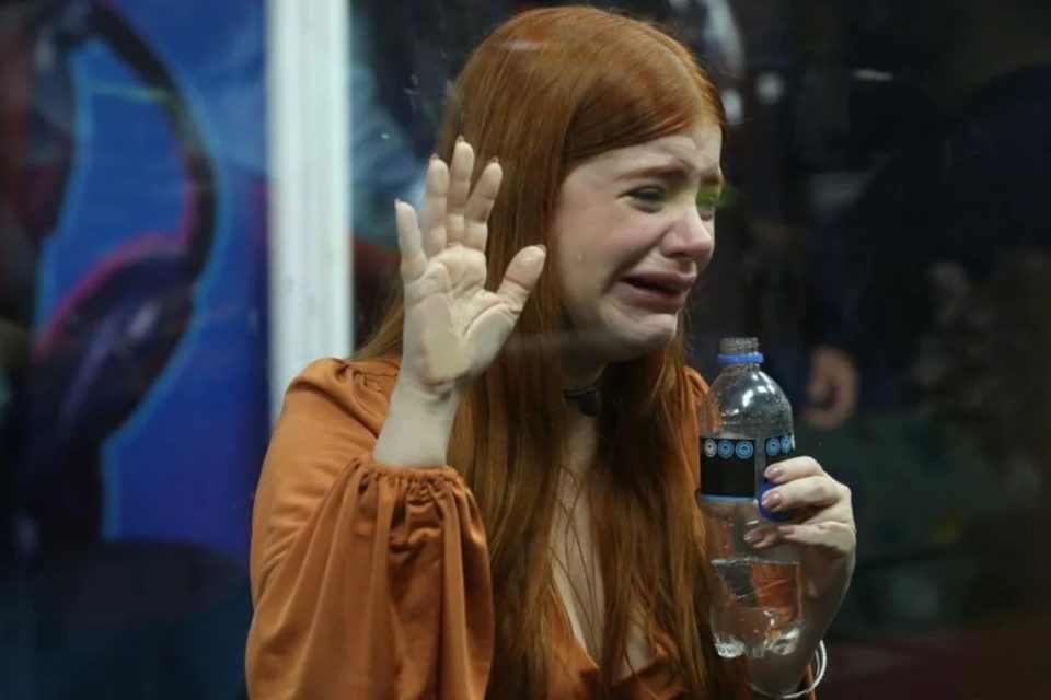 Foto colorida de Giovanna Leão chorando na Casa de Vidro do BBB23