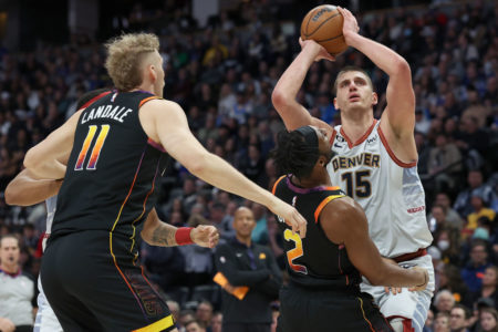 Luka Jokic arremessando entre adversários