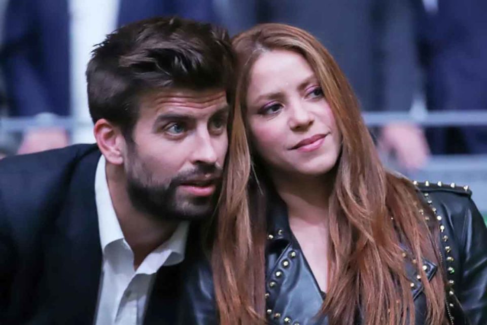 Foto colorida de Shakira e Gerard Piqué com os rotos colados, observando algo