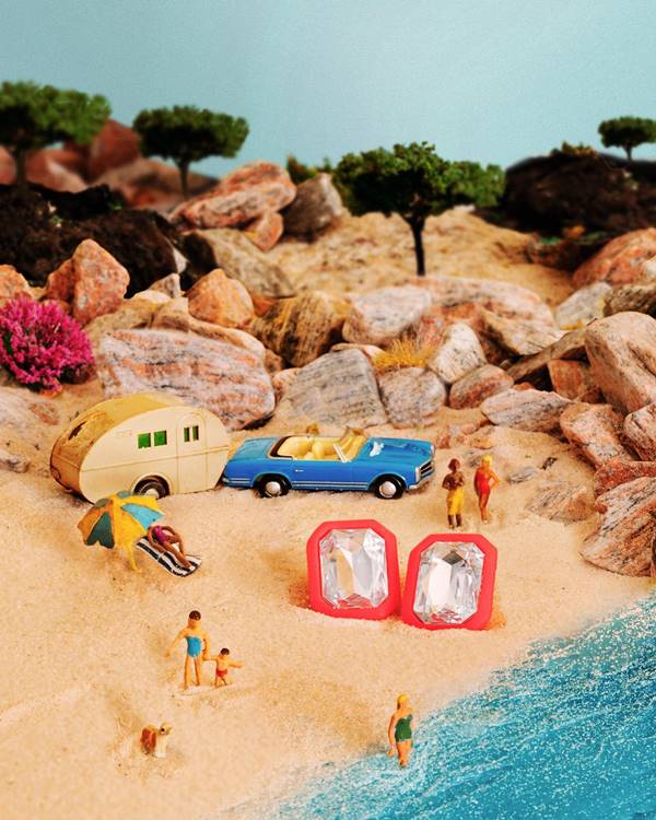 Brincos da marca Abi Project são posicionados em uma cenário de praia - Metrópoles