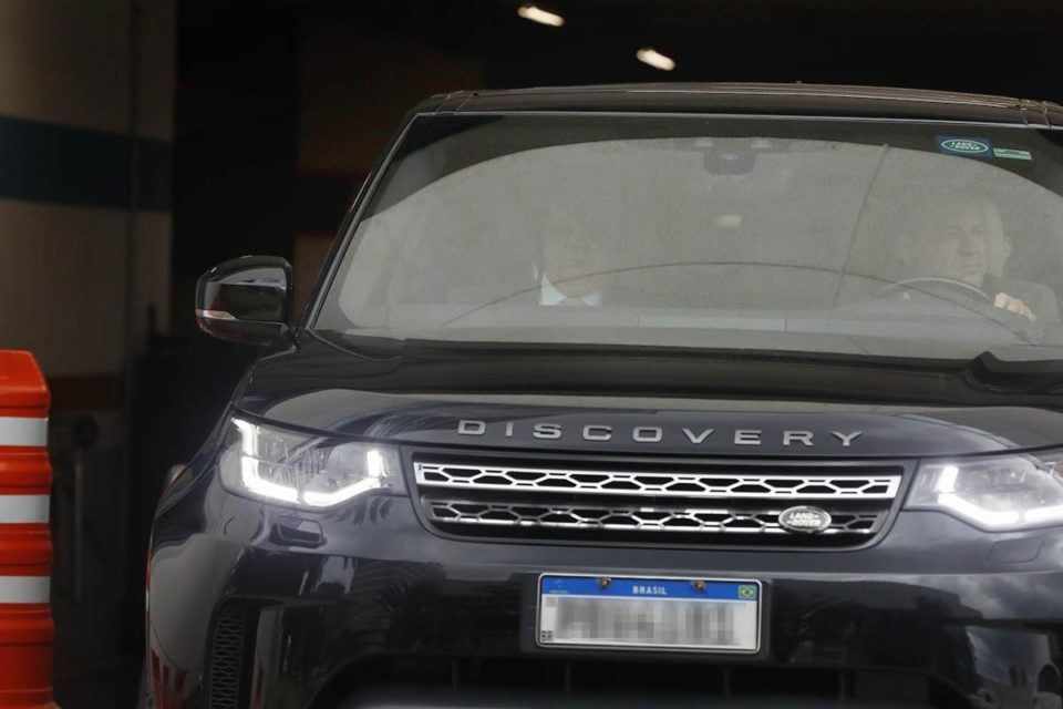 O governador afastado Ibaneis Rocha aparece sentado no banco de carona da frente de uma Land Rover preta após sair da Polícia Federal. Ele prestou depoimento sobre os ataques terroristas no DF de domingo - Metrópoles