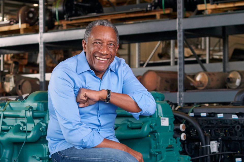 Foto colorida do empresário Geraldo Rufino sentado de camisa azule sorrindo - metrópoles