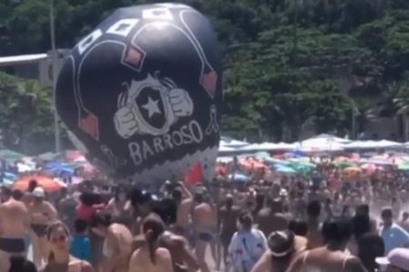 balão em cima de diversas pessoas em praia - metrópoles