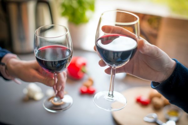 Na foto, duas pessoas seguram duas taças de vinho - Metrópoles