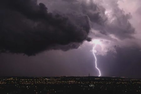 Imagem mostra um raio atingindo o solo de uma cidade