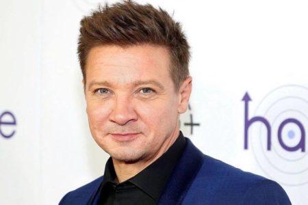 Jeremy Renner de camisa preta e terno azul - Metrópoles