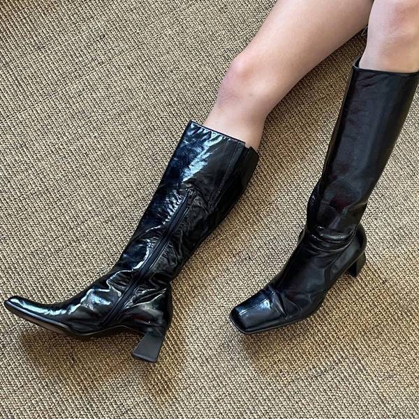 Modelo usa botas pretas de salto grosso - Metrópoles