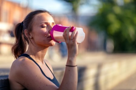 Mulher bebendo whey protein em coqueteleira - Metrópoles