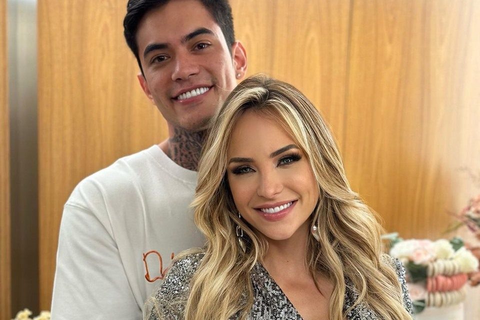 Gabi Martins posa com o namorado, Lincoln Lau. A cantora é loira, branca, tem olhos claros e usa roupa colorida Ele é branco, tem cabelo preto e está utilizando uma camisa branca - Metrópoles- Metrópoles