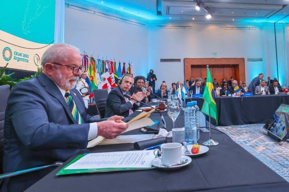 O presidente Lula participa do Celac em Buenos Aires, Argentina, ao lado de outros líderes da América Latina. Vê-se um salão grande, com telões, e diversos convidados cercando a mesa com os participantes - Metrópoles