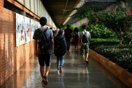 Imagem colorida de alguns alunos de costas no corredor do ICC na Universidade de Brasília