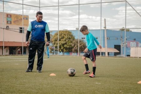 Imagem colorida mostra instrutor e aluno em curso de iniciação esportiva em Anápolis (GO) - Metrópoles