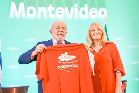 Imagem colorida mostra Lula em Montevidéu, no Uruguai. Ele está segurando uma camiseta ao lado da prefeita de Montevidéu, Carolina Cosse - Metrópoles