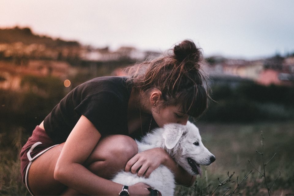 Mulher beijando cachorro