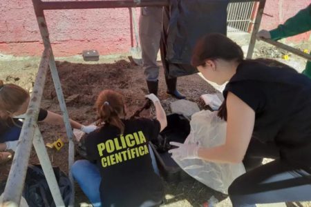 Foto colorida de agentes em um cemitério clandestino de cães - Metrópoles