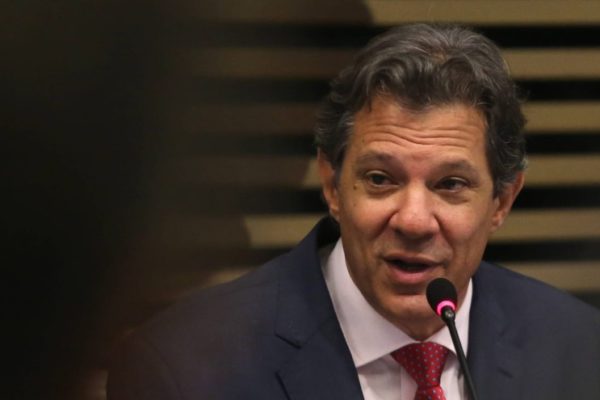 O ministro da Economia, Fernando Haddad, fala em palestra na FIESP, em São Paulo. Ele fala em microfone, sorrindo - Metrópoles