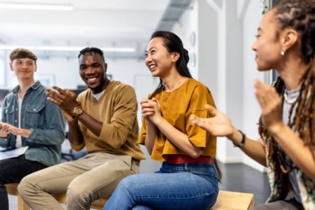 Grupo de pessoas socializando, rir e parcem bater palma