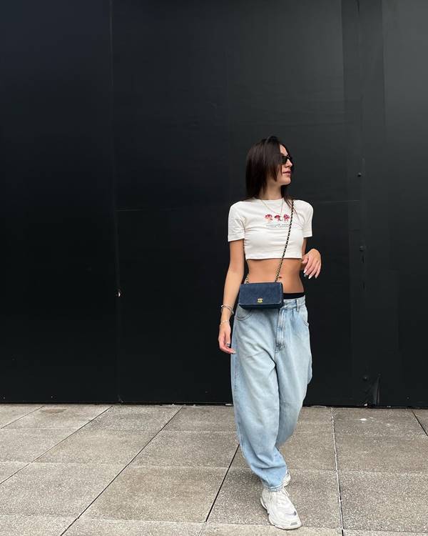 Influenciadora usa top branca, bolsa croossbody e calça jeans de cintura baixa - Metrópoles