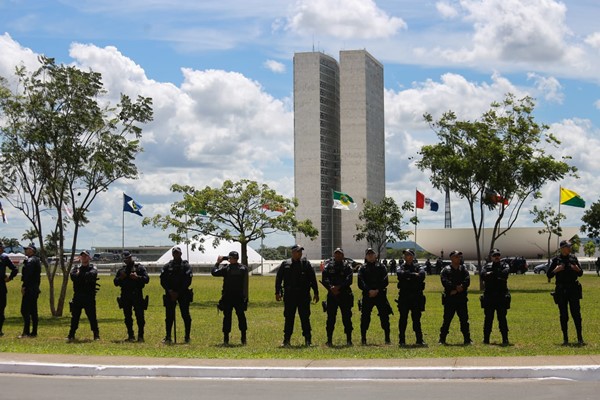 Foto colorida de policiais em pé em frete ao Congresso Nacional