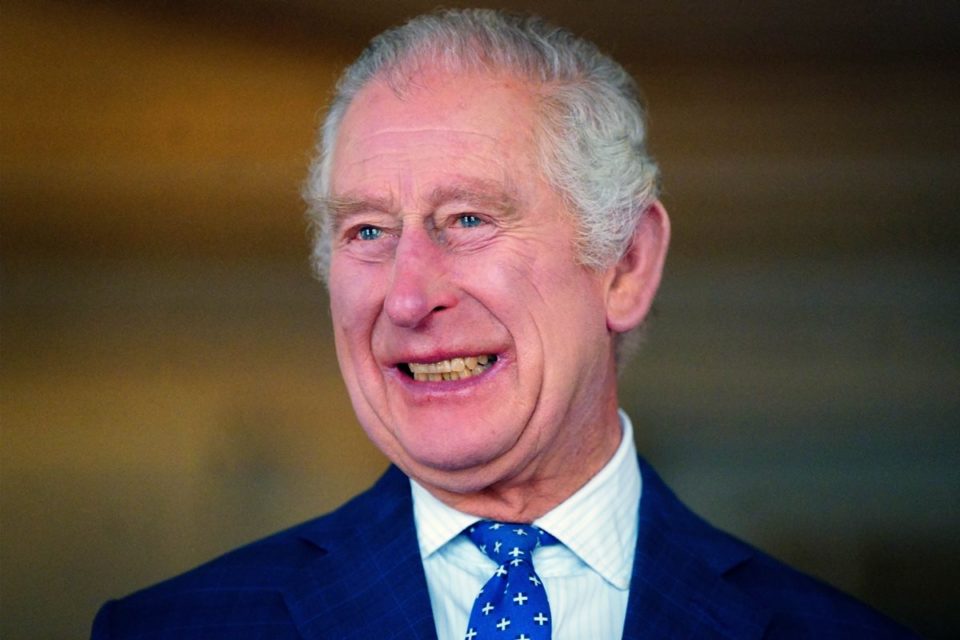 Foto colorida de homem idoso, branco, com cabelo grisalho, sorridente e vestido com blazer e gravata na cor azul - Metrópoles