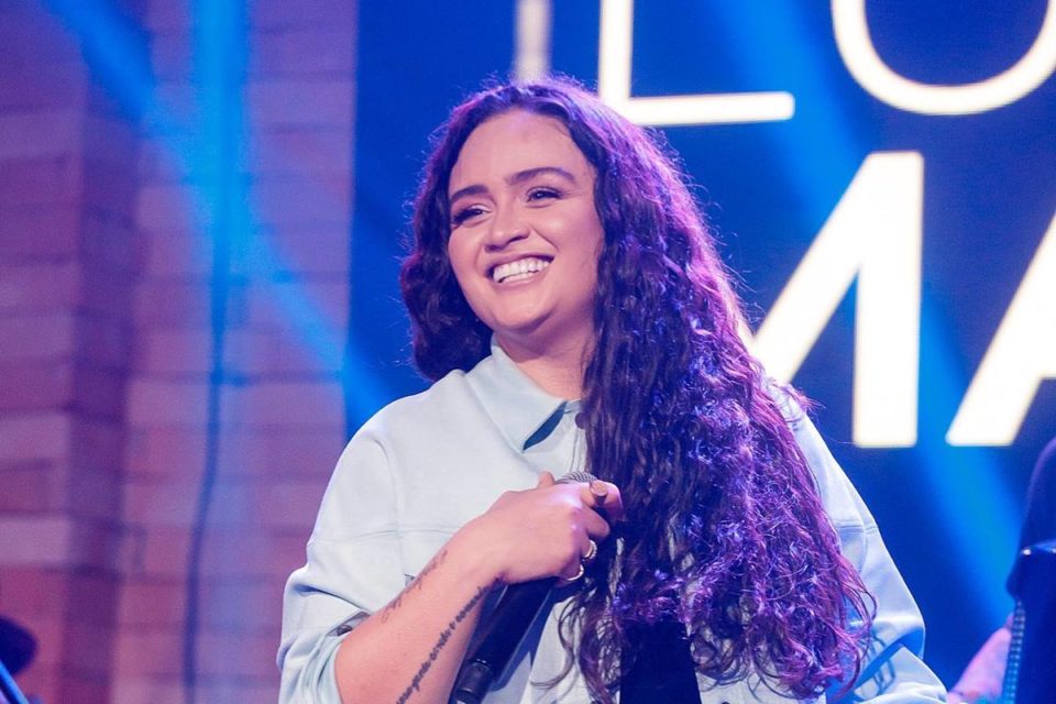 Foto colorida da cantora Luiza Martins em show