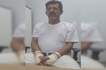 Homem de roupa branca sentado em cadeira