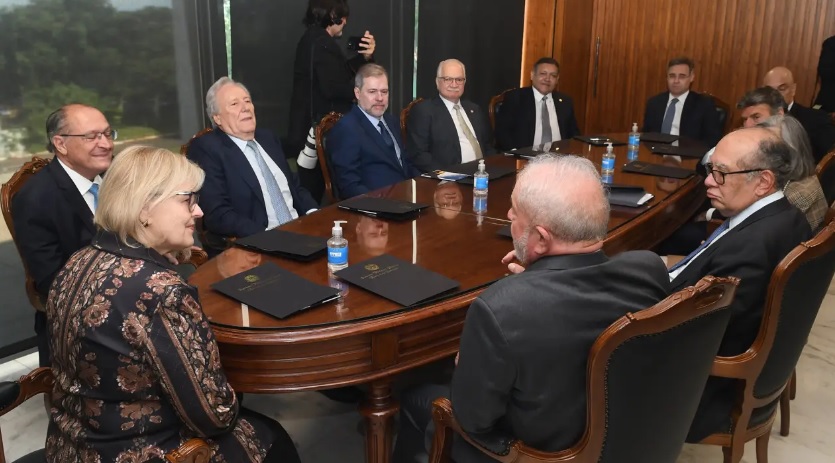 O presidente Lula em visita a ministros do STF após ser eleito. Eles se reúnem ao redor de mesa em sala no tribunal - Metrópoles