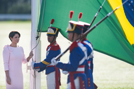 Michelle Bolsonaro segura a bandeira do Brasil no palacio do alvorada