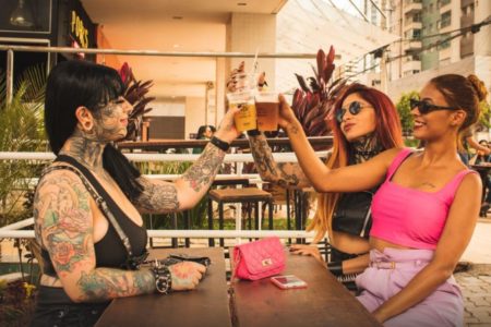 Três mulheres bebendo cerveja em um bar