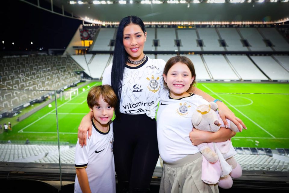 Foto colorida de Simaria e filhos em estádio