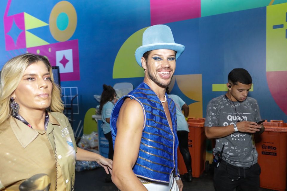 Foto colorida de José Loreto usando roupa colorida, chapéu azul e colete - Metrópoles