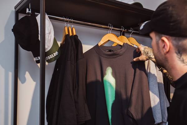 Dois homens com camisetas pretas posando para fotos de moda - Metrópoles