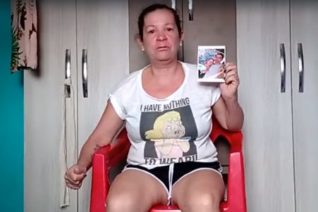 Mulher de camisa branca segura fotografia com a mão