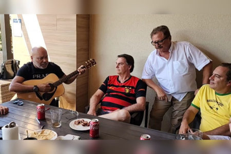 captura de tela mostra bolsonaro com camiseta de time de futebol ao lado de homem com violão e outras duas pessoas