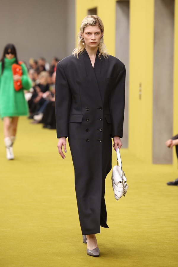 Na imagem com cor, mulher branca usa look preto para o desfile da Gucci - Metrópoles