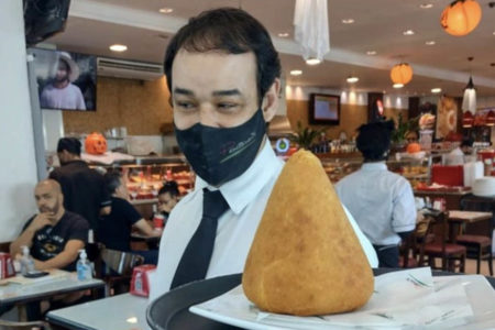 Garçom exibe a coxinha de quilo da padaria Panetteria ZN, em SP