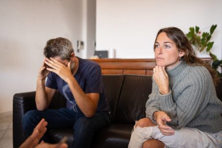 Casal brigando sentados em um sofá