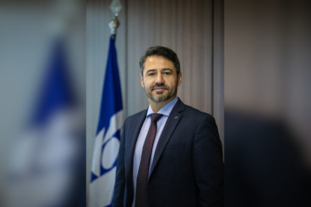 homem de terno ao lado de bandeira
