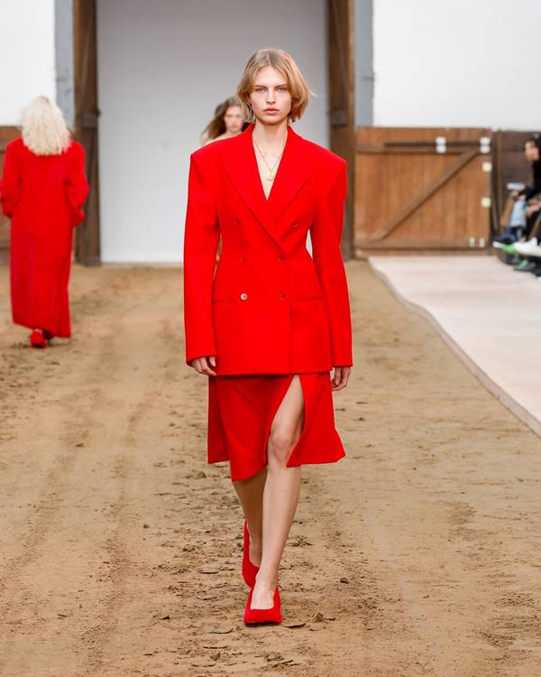 Modelo branca usa blazer vermelho, saia vermelha e salto felpudo vermelho - Metrópoles