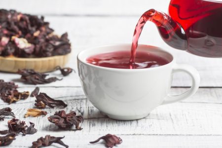 Imagem de chá de hibisco sendo servido em xícara branca - Metrópoles