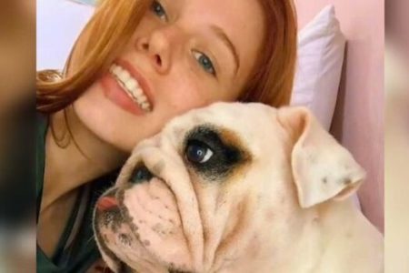 Fotografia colorida de Beatriz Amaral ao lado do cachorro que morreu logo após ser entregue pelo pet shop