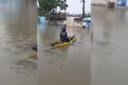 Morador usa caiaque para andar em rua alagada em SP