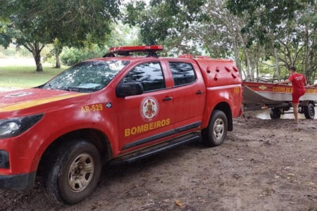 Fotografia colorida de viatura do Corpo de Bombeiros, que procura por menino que despareceu após pular no rio em pescaria com amigos