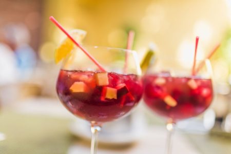 Drinks de sangria com frutas em taça com canudos