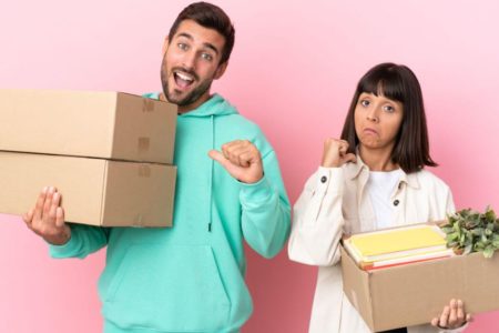 Homem e mulher segurando caixa de papelão nas mãos