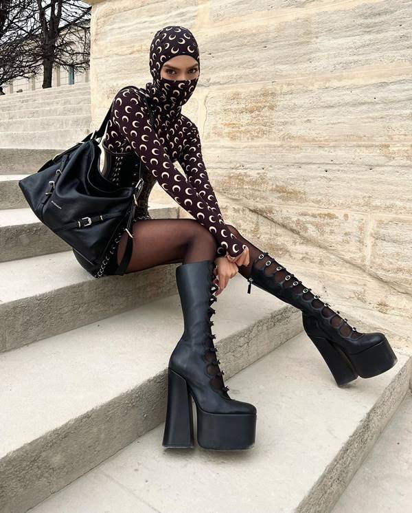 Influenciadora Jordanna usa botas pretas de salto, meia-calça, blusa longa e balaclava - Metrópoles