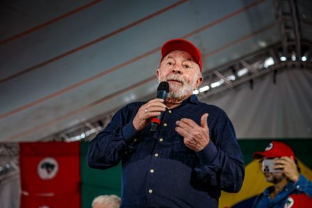 Lula discursa com bandeira do MST ao fundo