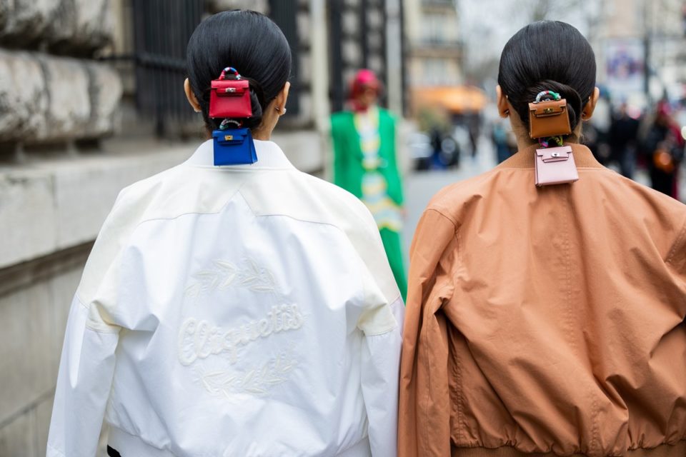 De costas, gêmeas usam minibolsas coloridos presas em penteado no cabelo - Metrópoles