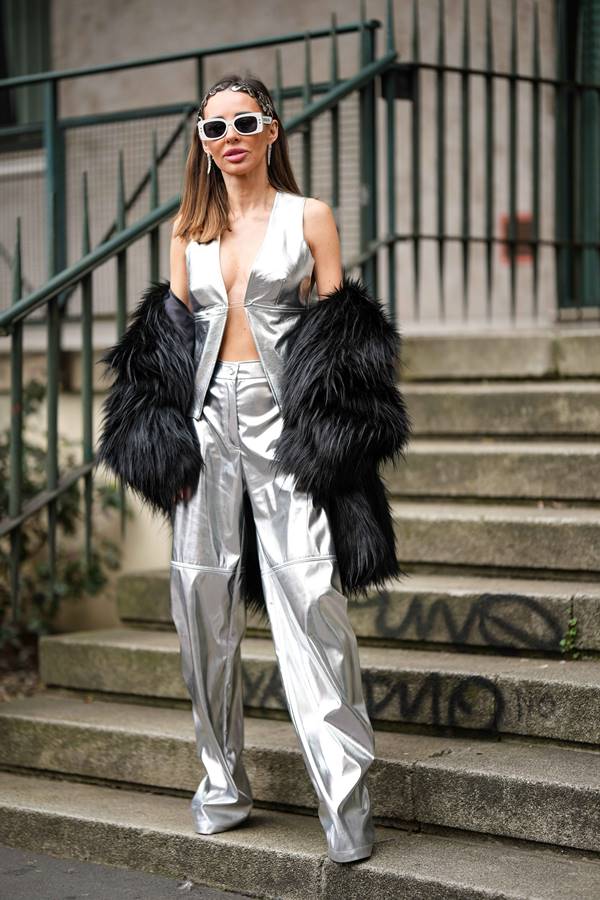 Mulher usa look prateado com casaco preto felpudo - Metrópoles